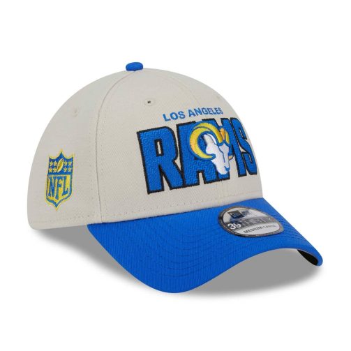 The official 2023 NFL Draft Cap from NFL supplier New Era features a two-tone design with high-quality embroidered logos. The front of the cap is embroidered with a large RAMS wordmark and the team logo in the background. Back features the official team logo, also embroidered. The NFL Shield on the right side of the cap completes the unique American football design. The cap crown is subtly stone gray, while the cap brim is designed in the official team color, creating a striking contrast. The underside of the brim is gray.